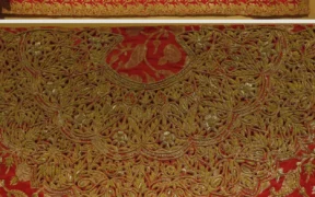 Gold zardozi embroidery on a red 20th-century wedding textile from Delhi, India.