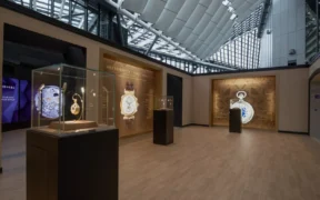 Patek Philippe Watch Art Milan 2026 exhibition gallery with vitrines and illuminated historic-watch displays.